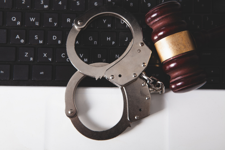 handcuffs and gavel on the keyboard of a computer.