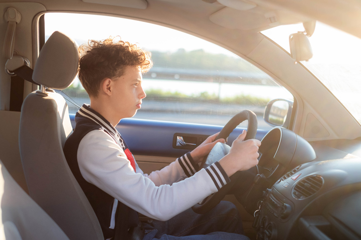 Teenager learning driving car during sunset