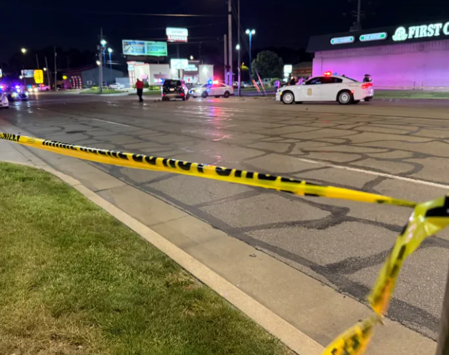 A nighttime scene with police cars, caution tape, and a First Cash business in the background.