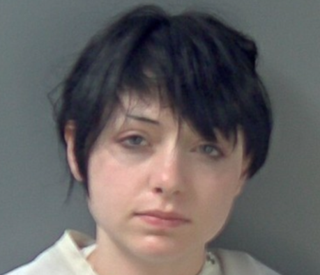 A young woman with short dark hair looking directly at the camera with a serious expression.
