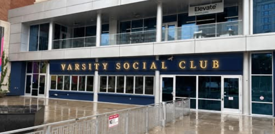 Exterior of the Varsity Social Club building with large text signage on the facade.