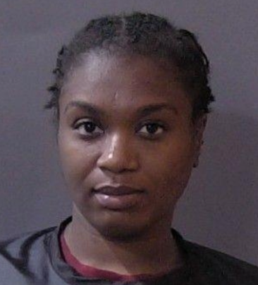 Portrait of a young Black woman with short curly hair looking directly at the camera.