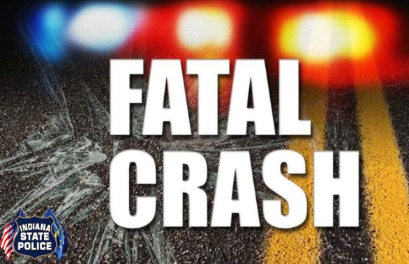 Fatal crash scene with emergency lights and damaged vehicle on the road.