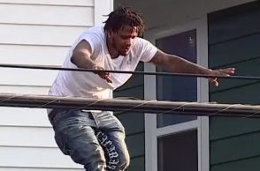 A person jumping from a roof onto a lower roof below.
