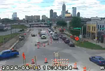 City skyline with traffic on a rainy street, construction cones visible