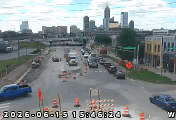 City skyline with traffic on a rainy street, construction cones visible