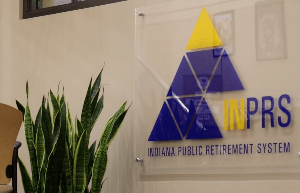 Indiana Public Retirement System logo on wall with potted plant in foreground.
