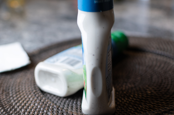 Bottles of ranch dressing with one on its side and one standing up right.