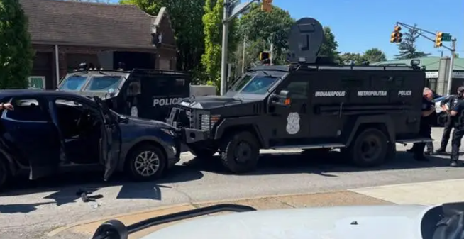 Several police vehicles, including an armored truck, parked on a city street with officers present.