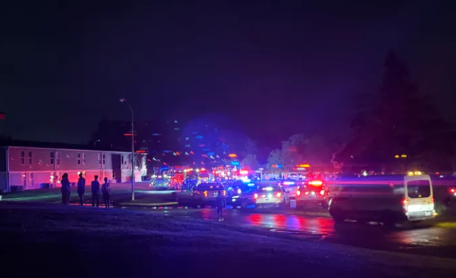 Emergency vehicles with flashing lights on a dark street at night