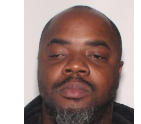 A close-up portrait of a middle-aged Black man with a beard, looking directly at the camera with a serious expression.