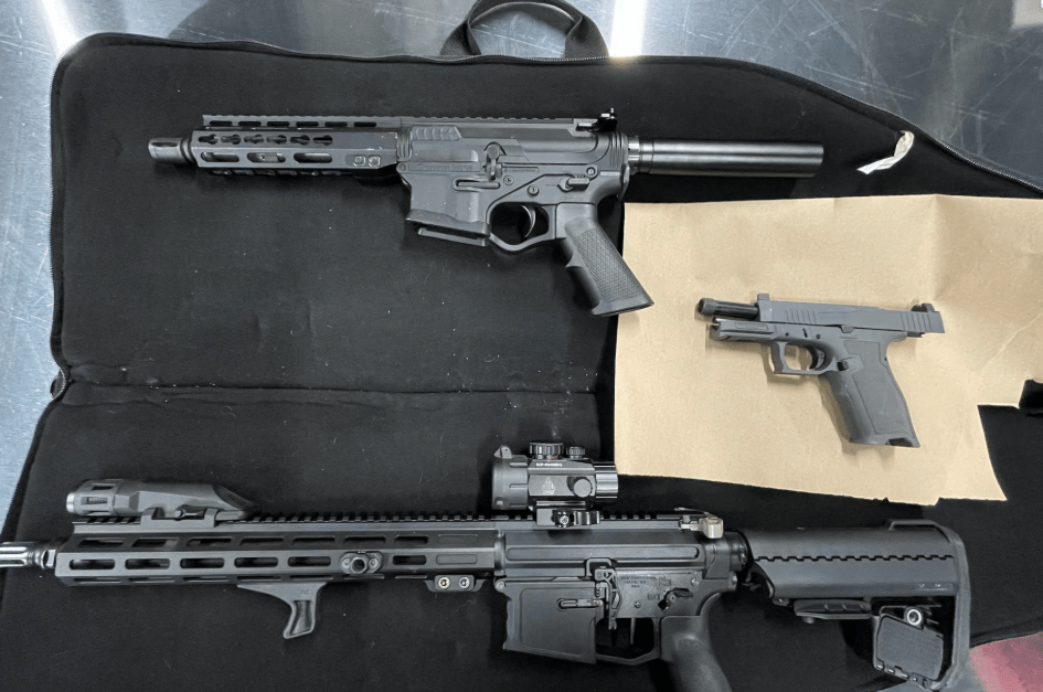 A black tactical rifle and a handgun in a black carrying case.