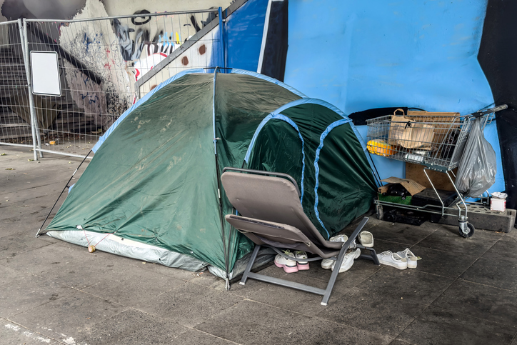 Homeless camp with a tent on a sidewalk