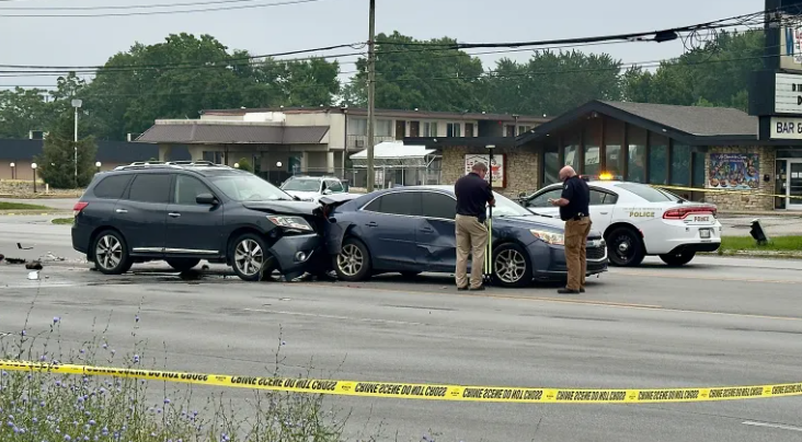 Multiple vehicles involved in a car accident on a city street, with police officers investigating the scene.
