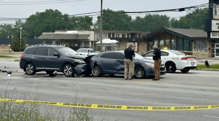 Multiple vehicles involved in a car accident on a city street, with police officers investigating the scene.
