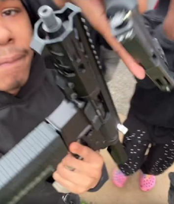 A person holding a large firearm in their hands.