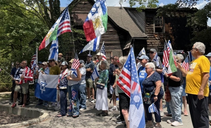 A crowd of people holding American and Israeli flags, gathered for what appears to be a political or patriotic rally or demonstration.