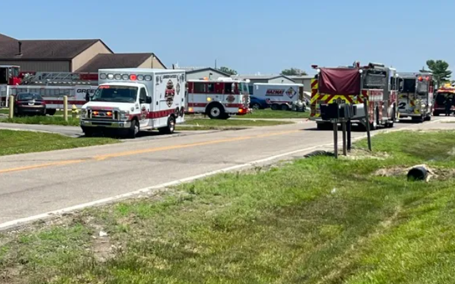 Emergency vehicles and equipment parked on a grassy roadside.
