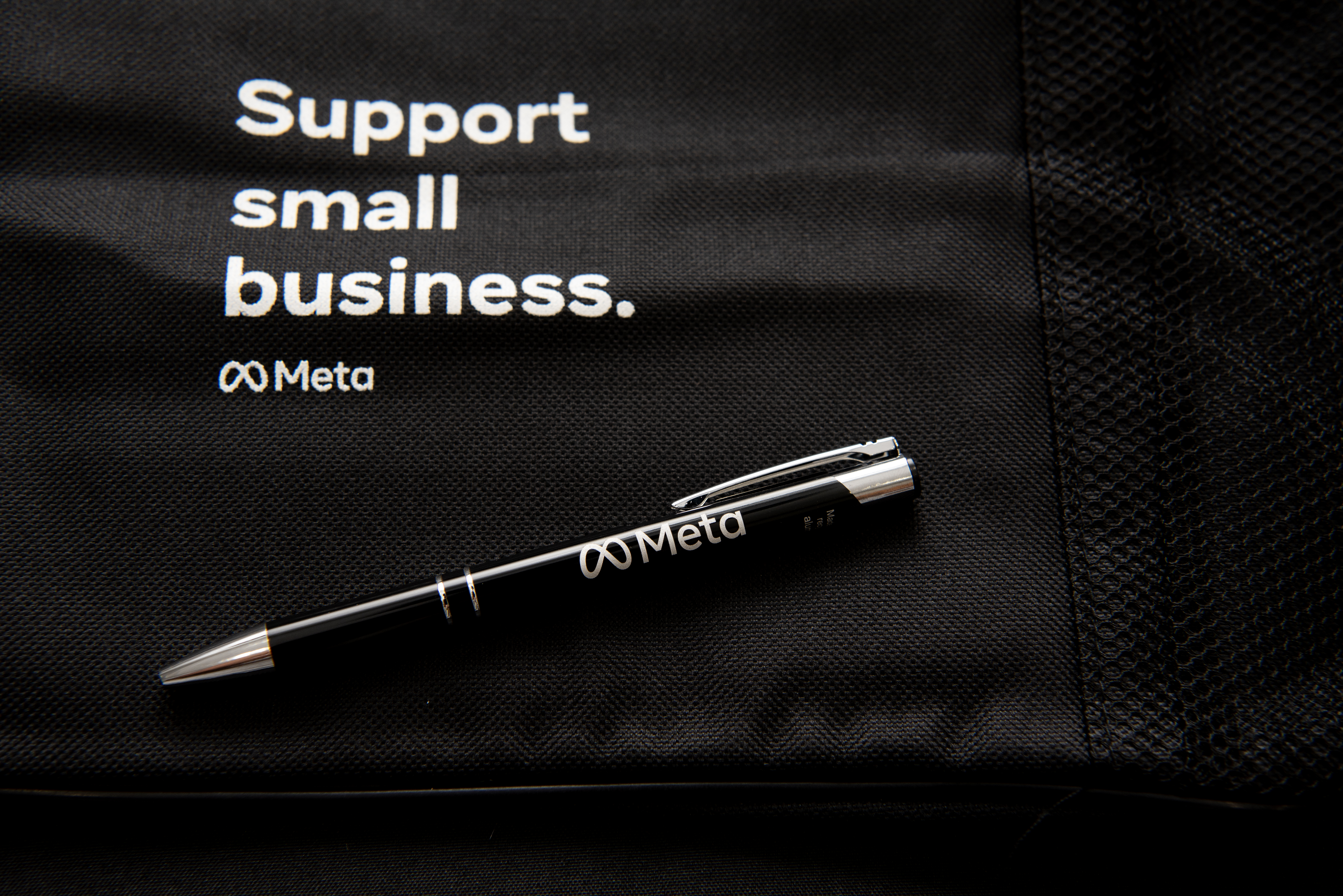 A black fabric bag with the text "Support small business." and the Meta logo.