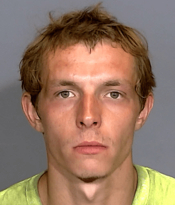 Headshot of a young man with short, tousled brown hair and a serious expression.