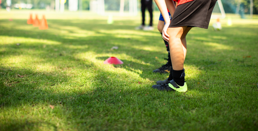 Junior soccer players practicing outside on a bright sunny day. Active lifestyle for kids.