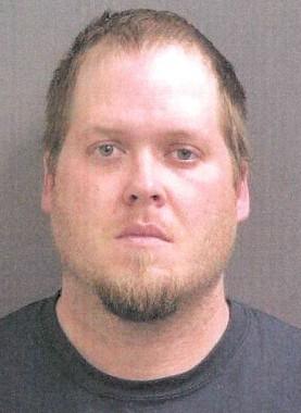 Headshot of a man with a beard wearing a black shirt.