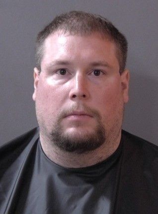 Headshot of a middle-aged man with a beard wearing a black shirt.