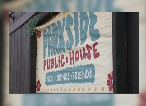 A sign for "Friendly Public House" advertising "Food, Drink, Friends" with colorful floral designs.