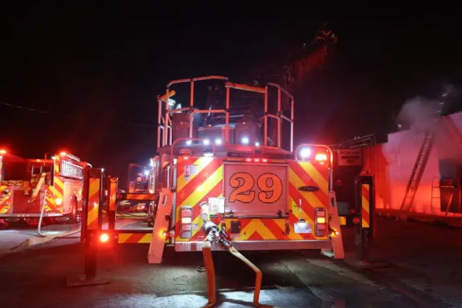 A fire engine with the number "29" on its side, its lights flashing in the dark night.