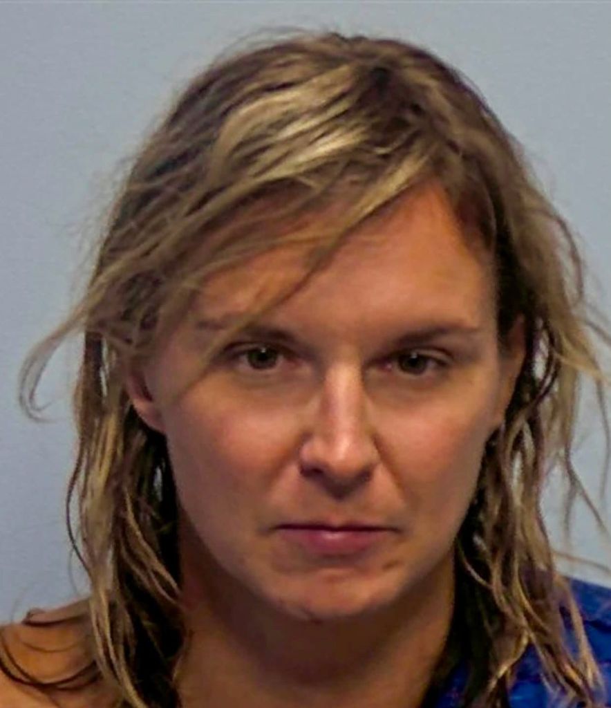 A middle-aged woman with shoulder-length blonde hair and a serious expression, wearing a blue shirt.