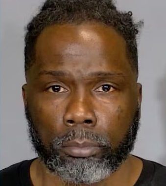 A middle-aged Black man with a beard and short curly hair, looking directly at the camera with a serious expression.