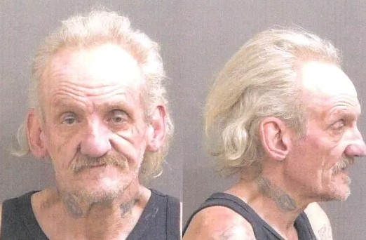 Two mugshot-style portraits of an older man with a long white beard and mustache, wearing a black shirt.
