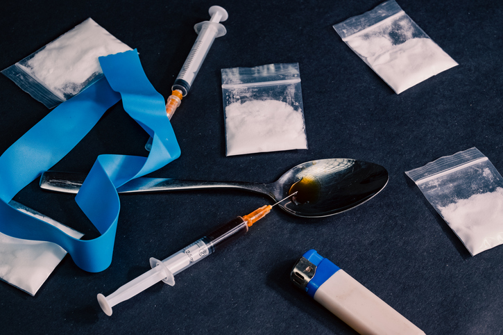 heroin is packaged in small bags, syringes and pills are burned nearby