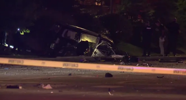 Damaged vehicle on dark street at night, with debris and police tape visible.