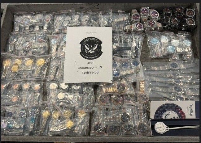 A collection of various items, including jewelry, accessories, and other small objects, displayed in clear plastic bags and containers, with a sign indicating the location as the Indianapolis FedEx Hub.