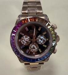 Stainless steel chronograph watch with multicolored bezel and dial displaying various time zones.