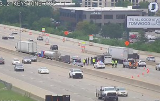 Highway with multiple lanes, vehicles, and emergency responders on the scene.