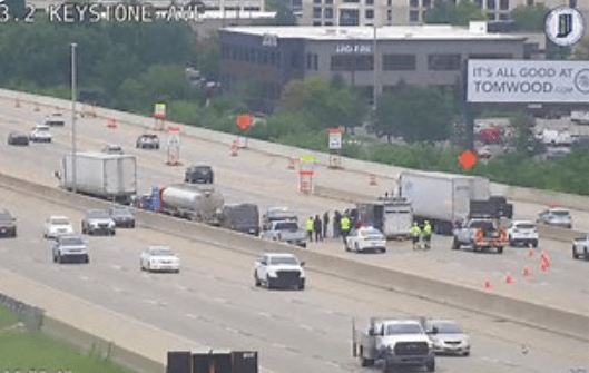 Highway with multiple lanes, vehicles, and emergency responders on the scene.