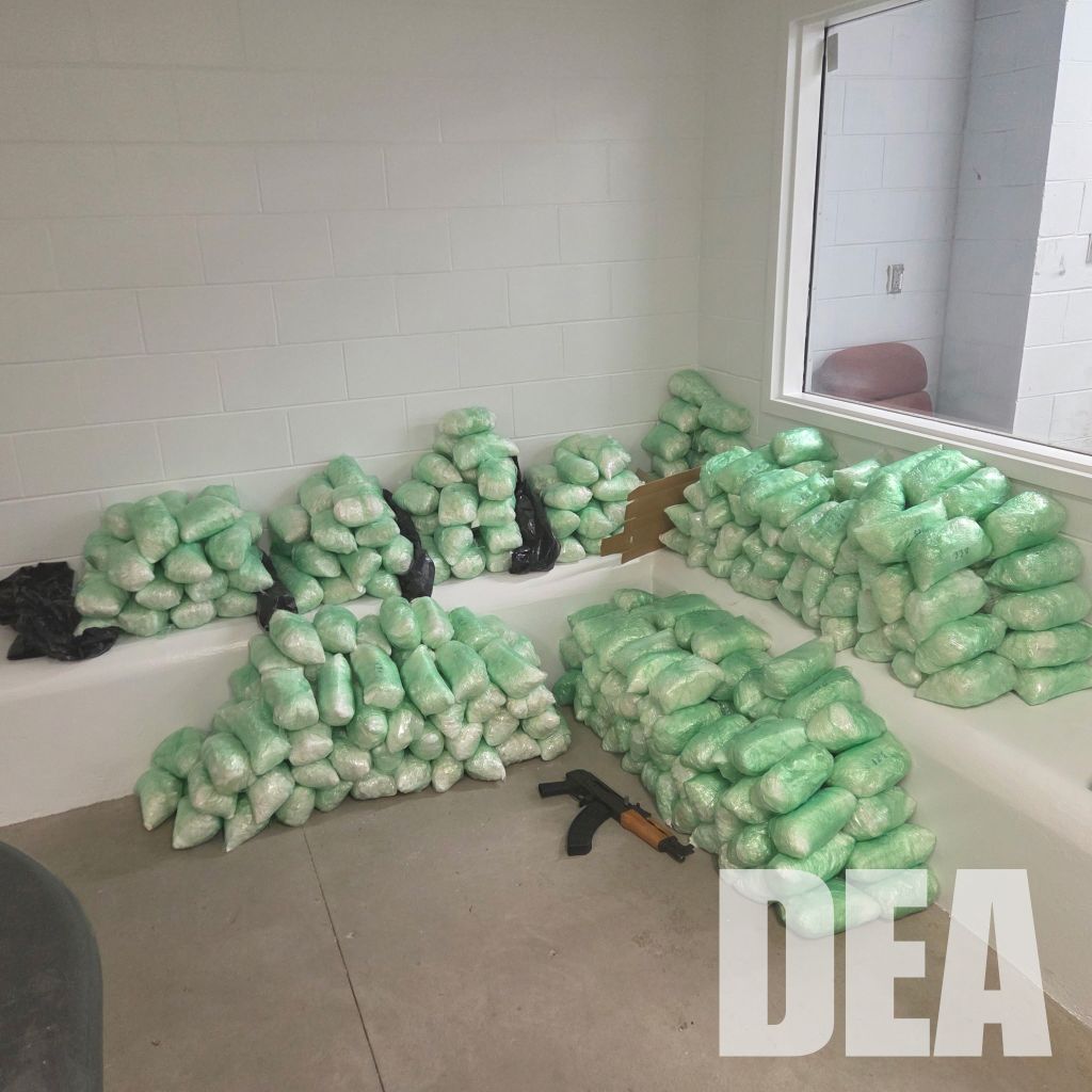Numerous packages of what appears to be green, crystalline substance, possibly a controlled substance, scattered on the floor.