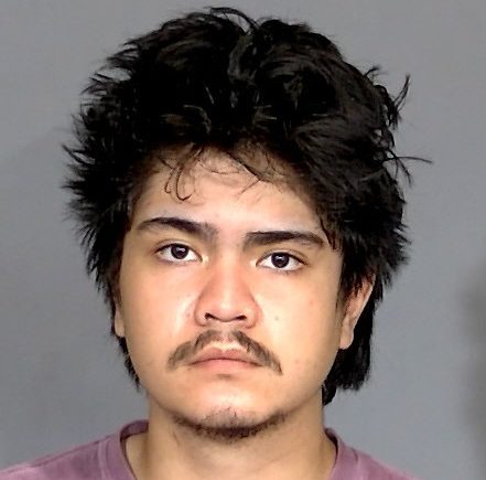 Headshot of a young Asian man with dark, spiky hair and a serious expression.