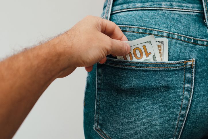 Money in the pocket. Stealing money Concept finance with Bundle of dollar. Human hand taking money from jeans pocket.