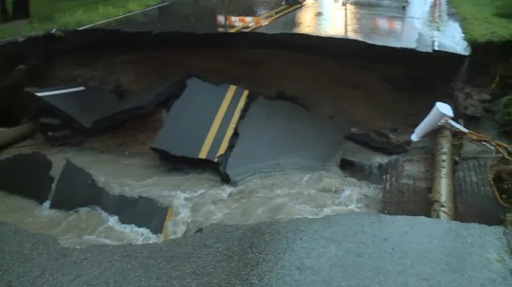 Debris scattered on a wet road, including broken pieces of what appears to be a vehicle.