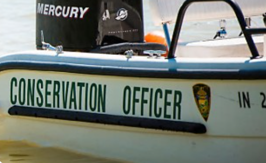 A small boat with "CONSERVATION OFFICER" written on the side and a Mercury outboard motor.
