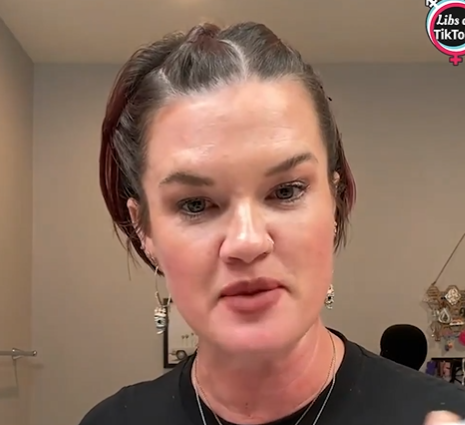 A woman with dark hair and makeup looking directly at the camera with a serious expression.