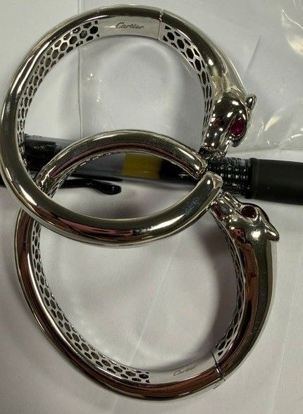 A pair of silver-toned Cartier eyeglasses with a distinctive patterned design.