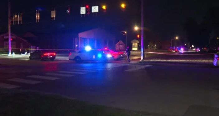 Night scene with police car on the street, its lights flashing.