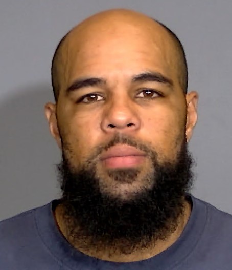 Headshot of a bald man with a thick beard looking directly at the camera.